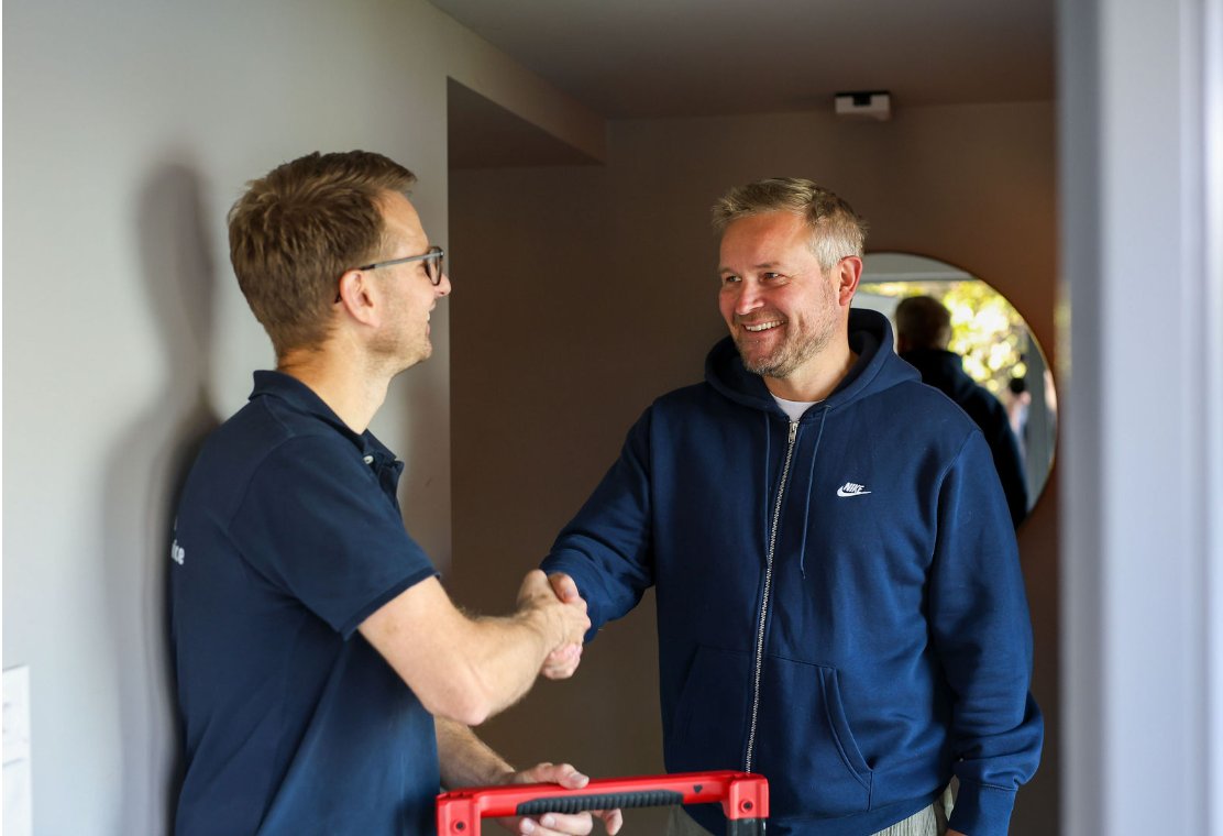 Tekniker fra Øygarden Klimaservice håndhilser på en fornøyd kunde