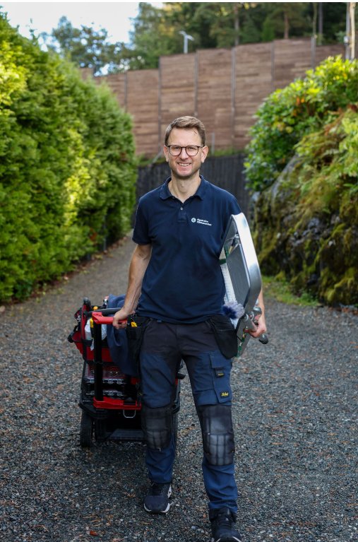 Tekniker fra Øygarden Klimaservice på vei inn til kunde med utstyr