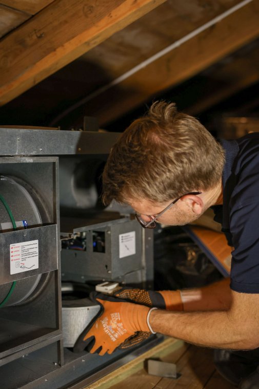Tekniker åpner og tar service på et ventilasjonsaggregat på loftet
